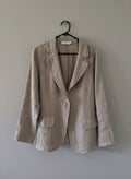 Elora Linen Blazer in fango – flat lay on hanger showing single button fastening, decorative stitching along lapels, rounded front panels and flap pockets | Sonella